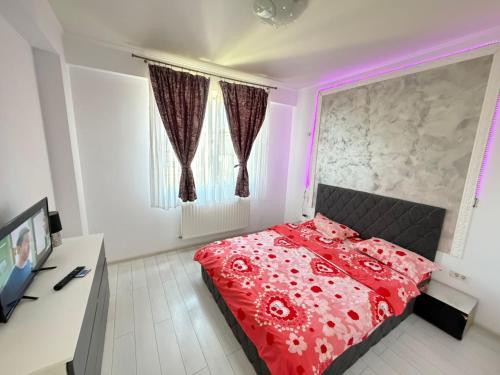 a bedroom with a red comforter on a bed at RC RelaxApart 820 in Dudu