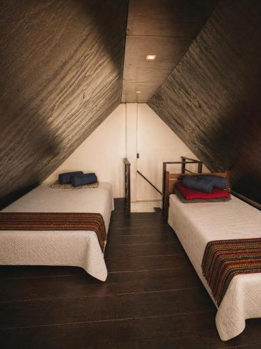 a room with two beds in a attic at Cabañas La PetiteChef in El Limar