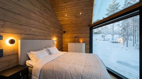 a bedroom with a bed and a large window at Levi Nordic Star Igloos in Levi