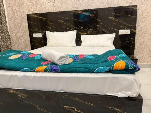 a large bed with a colorful blanket on it at Sukoon studios in Ghaziabad