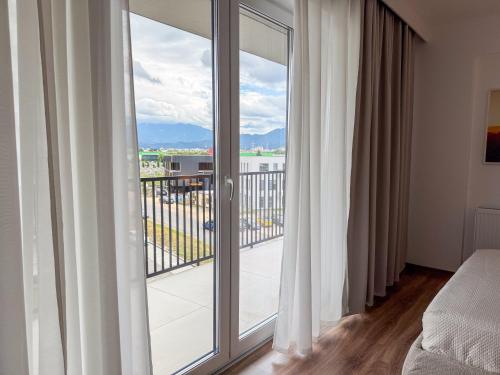 a bedroom with a balcony with sliding glass doors at Modern Spacious Mountain View Apt in Braşov