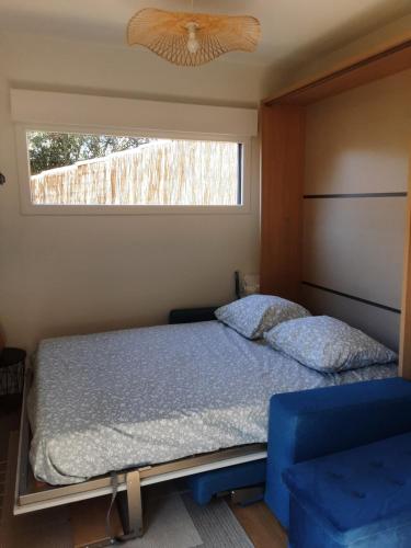 a bedroom with a bed and a window at Studio de jardin dans son écrin de verdure in Saint-Lumine-de-Coutais