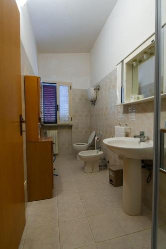 a bathroom with a sink and a toilet and a mirror at Casa La Pigna in Lucito