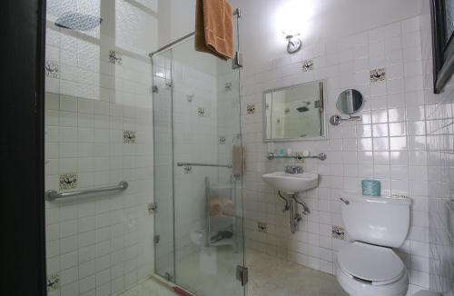 a bathroom with a shower and a toilet and a sink at Hotel Casino Morelia in Morelia