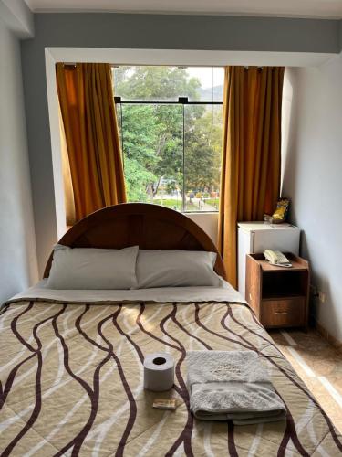 a bedroom with a bed with a large window at Hotel las vegas in Huánuco