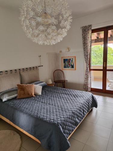 a bedroom with a large bed and a chandelier at Agriturismo Tenuta Blueberry - Glicine in Varallo Pombia