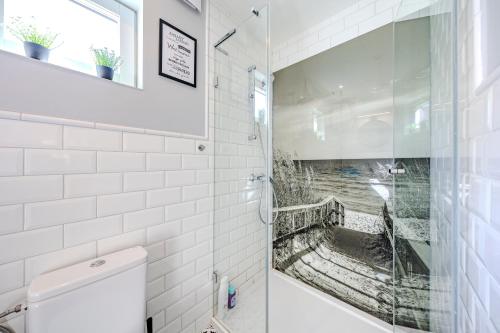 a bathroom with a shower with white tiles at Nowoczesny domek z klimatyzacją i tarasem, blisko plaży Stegna House in Stegna