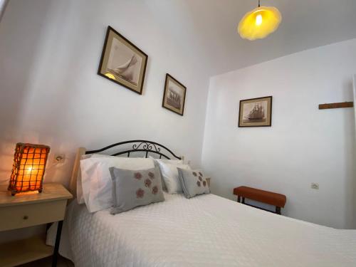 a bedroom with a bed and a nightstand with a lamp at Ravanos Apartment in Loutraki