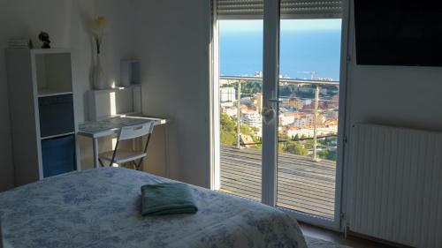 a bedroom with a bed and a view of a balcony at Villa Azur Horizon in La Turbie