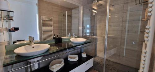 a bathroom with two sinks and a glass shower at Villa Azur Horizon in La Turbie