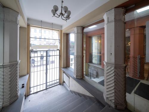 a room with a balcony with large windows at M6 Rooms Riga in Riga