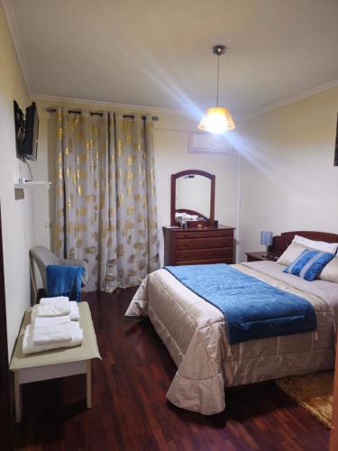 a bedroom with a bed and a table and a mirror at Madeira Home Holidays in Caniço