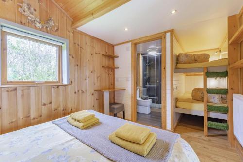 a bedroom with wooden walls and a bed with yellow towels at 1 Bed in Barnacre oc-b34349 in Catterall