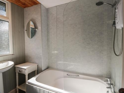 a white bath tub in a bathroom with a sink at Kouloura in Mainsriddle