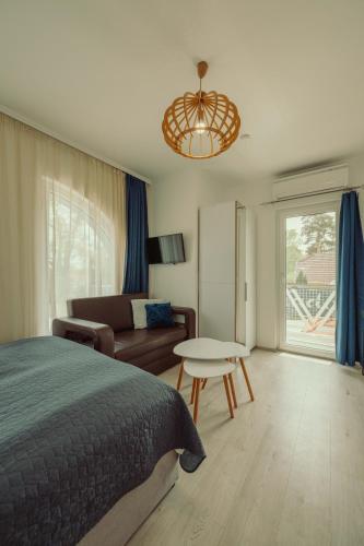 a bedroom with a bed and a couch and a table at Caesar Apartments & Rooms in Siófok