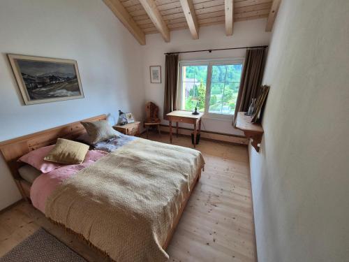 a bedroom with a bed with a large window at Chesa Clavazzin in Brunnadern