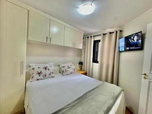 a bedroom with a large white bed with two pillows at Flat Moema Apart La Maison D´Stan 02 DTS - UH82 in São Paulo