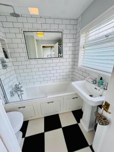 a bathroom with a white tub and a sink and a toilet at 31 Sailsbury road in Marlborough