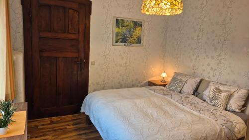 a bedroom with a bed and a wooden door at Villa Charlotte in Bad Liebenstein