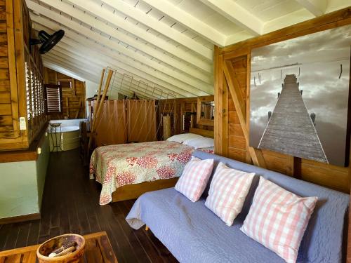 a bedroom with a couch and a bed in a room at La Voile Grise - Villa de charme - Sea View in Le Gosier