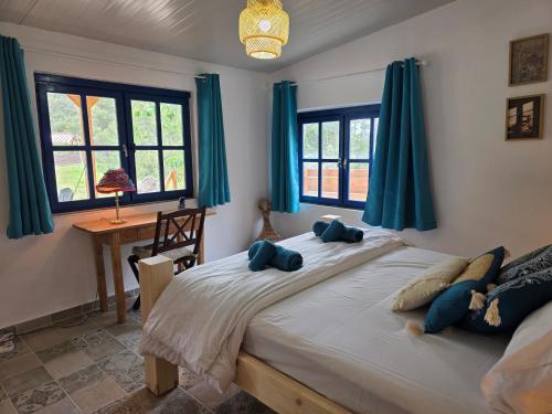 a bedroom with a large bed with blue curtains at Kellaki Village House in Kellaki