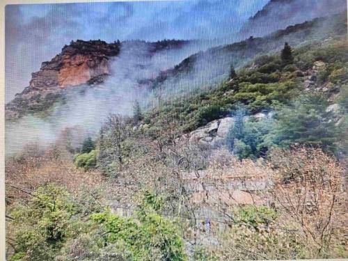 a view of a mountain with smoke coming out of it at Ζachlorou Inn in Kalavrita