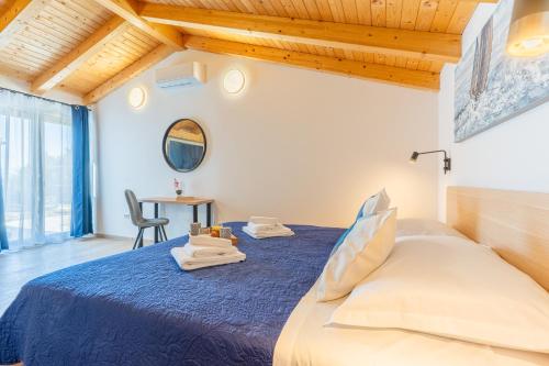 a bedroom with a bed and a table with a chair at Villa Lareva - sunset view in Ustrine