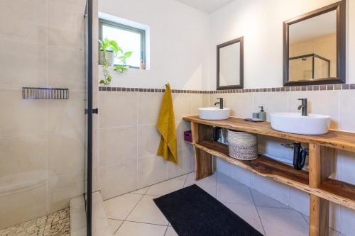 a bathroom with two sinks and a shower at Garden View Studio in Plettenberg Bay