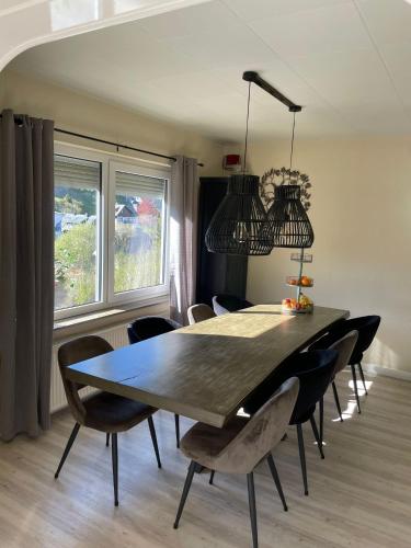a dining room with a black table and chairs at Hausamaarbach in Willingen