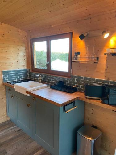 a kitchen with a sink and a counter with a window at La Roulotte du Marais in Éclusier-Vaux