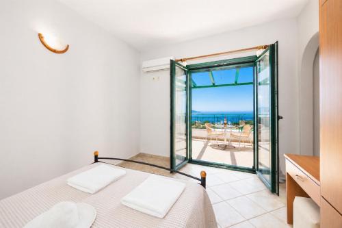 a bedroom with a bed and a view of the ocean at Villa Vera in Dhrapanítika