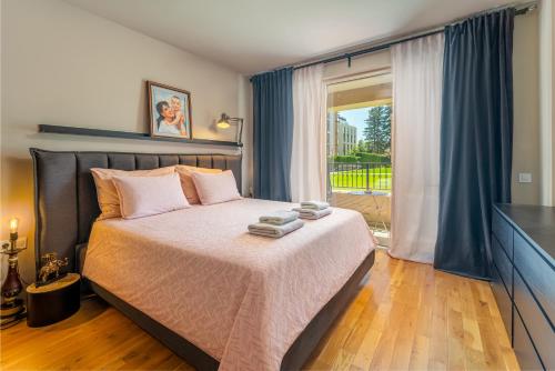 a bedroom with a bed and a large window at Les Faberges in Carpe Vita in Varna City