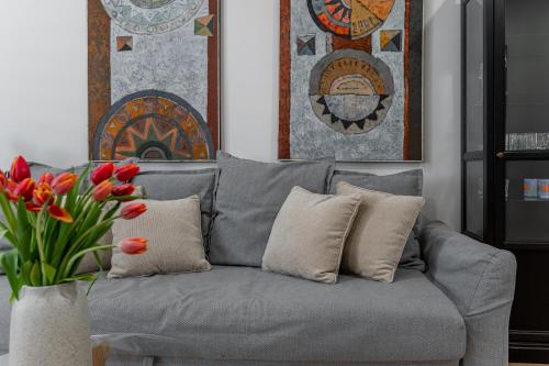 a grey couch with red tulips in a living room at Centrum Kosice Apartment 60m2 4 beds in Košice