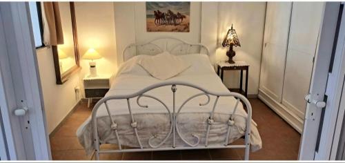 a bedroom with a white bed and two night stands at Ptit Piment petite maison avec terrasse in Lanton
