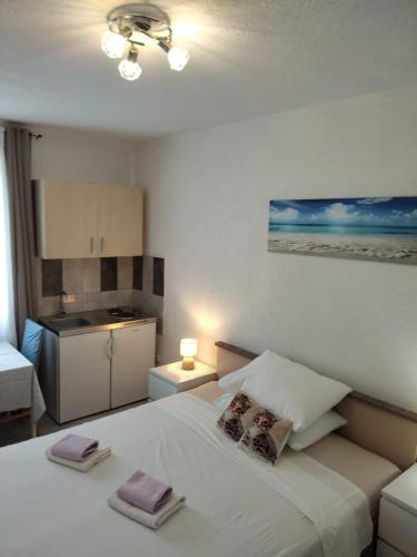 a bedroom with a white bed with two pillows on it at Apartmani Mila-Casa Bianca in Medulin