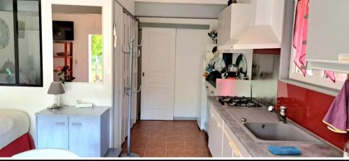 a kitchen with a sink and a stove top oven at Ptit Piment petite maison avec terrasse in Lanton