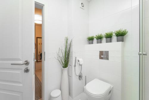 a bathroom with a toilet and plants on the wall at Les Faberges in Carpe Vita in Varna City