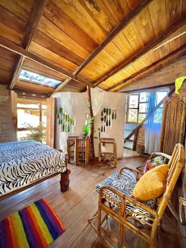 a bedroom with a bed and chairs in a room at Hotel Casa Tarzan San Agustin in San Agustín
