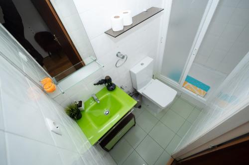 a bathroom with a green sink and a toilet at Large 1-Bedroom 1 Doble bed 1 Sofa bed 1 Bathroom Duplex Apartment Prime Lisbon Location in Lisbon
