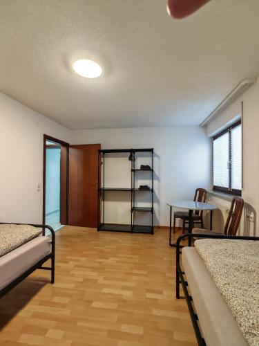 a room with beds and a table and a shelf at Ferienwohnung Unterkunft 24 in Aldingen