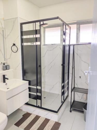 a glass shower in a bathroom with a sink at Stella Maris 123 in Amanzimtoti
