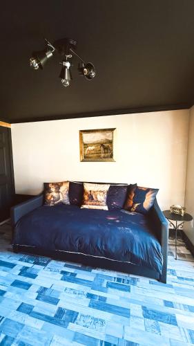 a bedroom with a blue bed with a ceiling at Domaine Taïga - Parc animalier en forêt in Sainte-Agathe-des-Monts