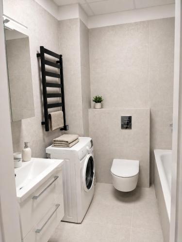 a white bathroom with a washing machine in it at Apartment Ainiai in Panevėžys