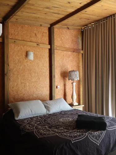 a bedroom with a bed with a wooden ceiling at Suites Guarda do Embau in Palhoça