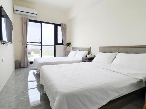 a bedroom with two beds with white sheets at Starry Night Travel Homestay in Magong