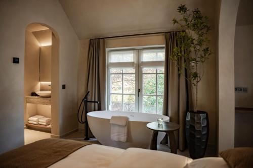 a bathroom with a bath tub and a window at Le Diez Boutique Hotel in Den Bosch