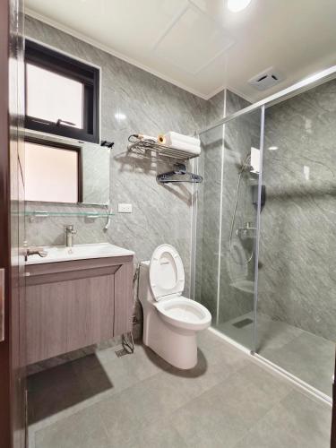 a bathroom with a toilet and a glass shower at Starry Night Travel Homestay in Magong