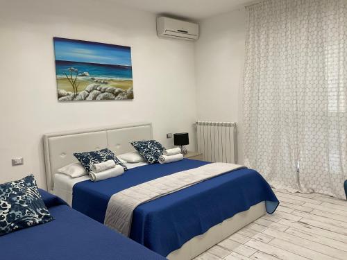 a bedroom with two beds and a painting on the wall at Naxos Maréa Apartament in Giardini Naxos