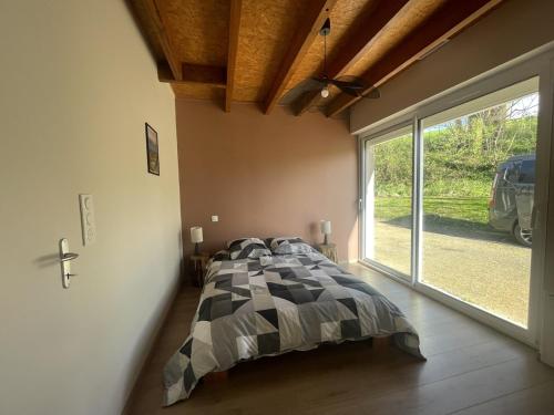 a bedroom with a bed and a large window at L'Atelier de Gabs in Aramits