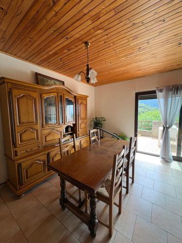 a dining room with a wooden table and chairs at appartement olivese in Olivese